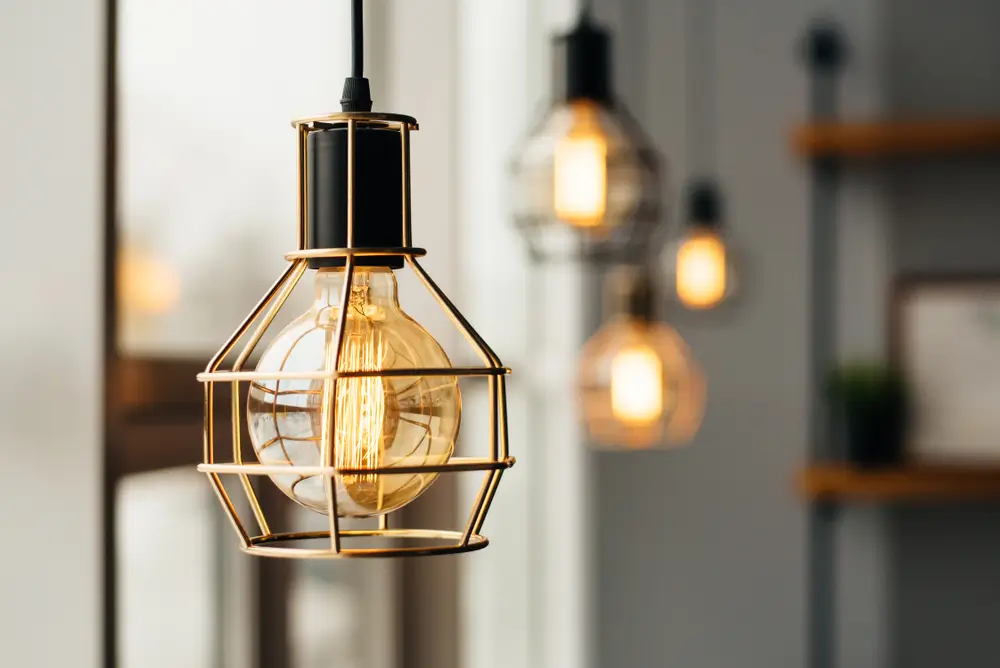 Des ampoules de style loft brillent près de la fenêtre. Lumière chaude. A l'intérieur de la boutique de café.