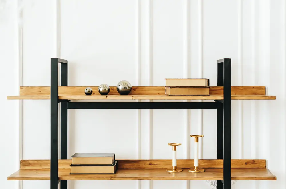 Des étagères en bois décoratives dans le salon avec livres et chandeliers.